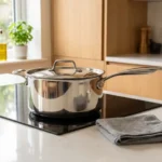A clean and shiny stainless steel pot sitting on a stovetop after being restored using methods on how to clean burnt stainless steel pots
