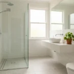 - Cleaning Tips Today Clean bright bathroom with white tiles and glass shower door showing good ventilation to prevent mold