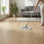 Person cleaning vinyl plank flooring with a microfiber mop in a bright living room