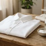 Close up of a white cotton shirt with baking soda and vinegar used to remove old stains