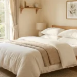 Fluffy clean white pillows on a bed in a sunlit bedroom