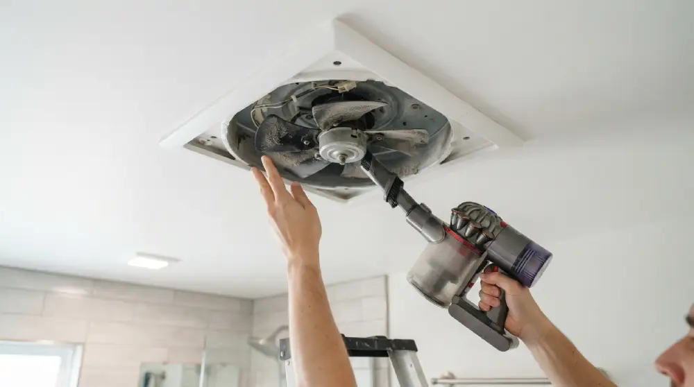 - Cleaning Tips Today Hands cleaning bathroom exhaust fan blades with a vacuum brush attachment
