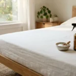 Clean white mattress with baking soda and natural cleaning spray in a sunlit bedroom