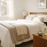Clean fresh bed with white linens in a sunny bedroom after removing mattress odors
